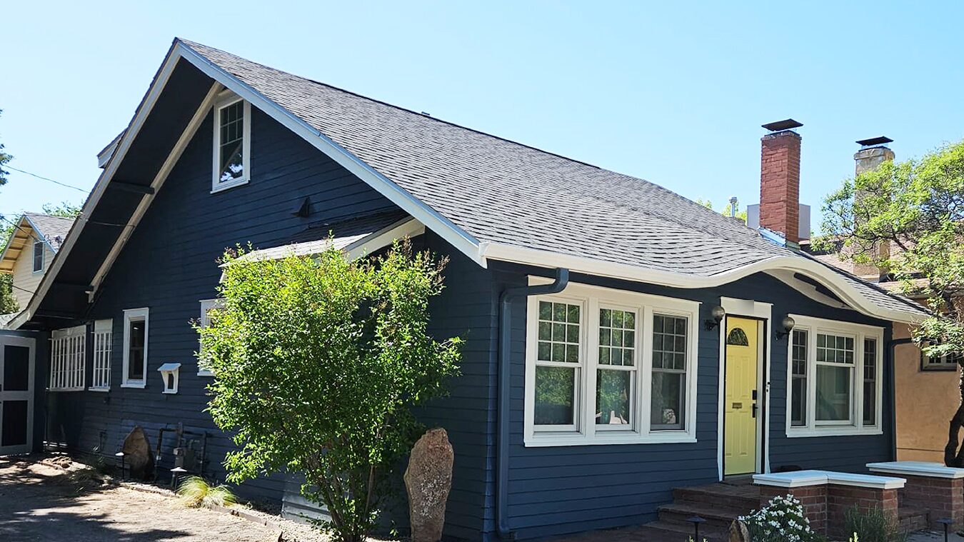 Navy blue craftsman home exterior with white trim and a yellow front door