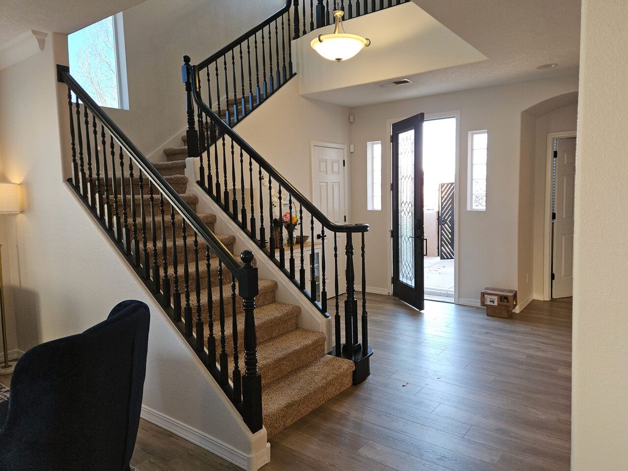 Entryway staircase with black-painted railing and balusters