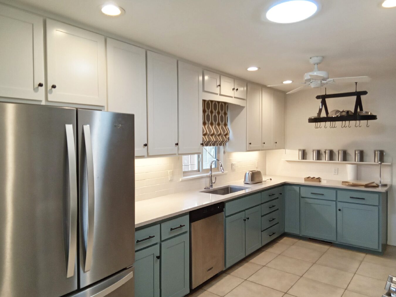 Kitchen with white upper cabinets and teal lower cabinets