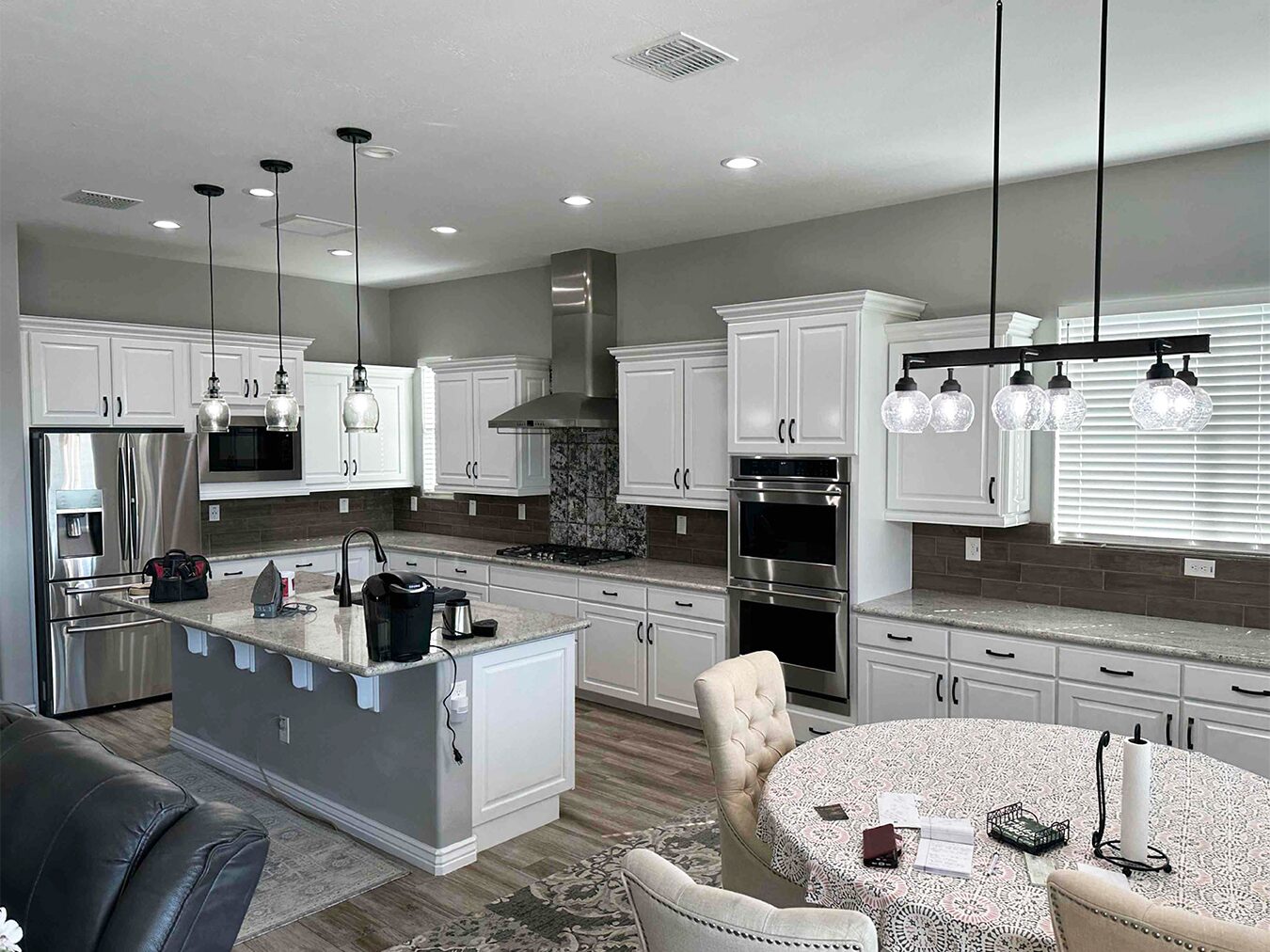 Kitchen with white-painted cabinets, grey walls and pendant lights